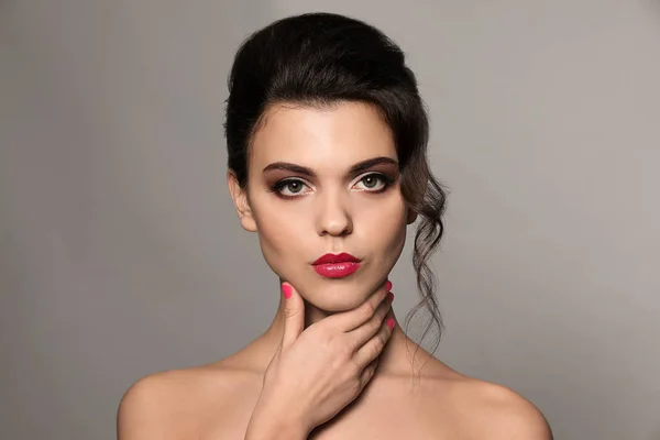 Porträt einer jungen Frau mit wunderschönem professionellen Make-up auf grauem Hintergrund — Stockfoto