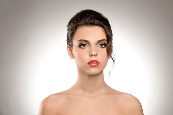 Retrato de mujer joven con hermoso maquillaje profesional sobre fondo claro —  Fotos de Stock