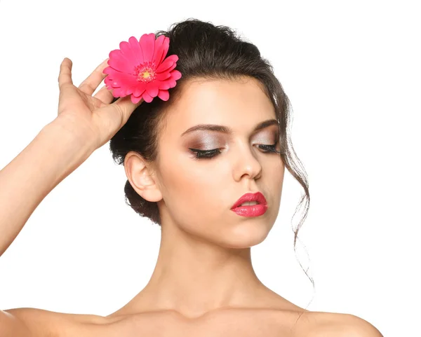 Portrait of young woman with beautiful professional makeup and flower on white background — Stock Photo, Image