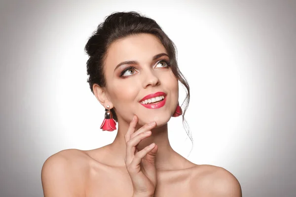 Porträtt av känslomässiga ung kvinna med vackra professionell makeup på ljus bakgrund — Stockfoto