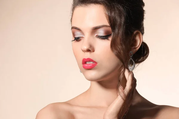Retrato de jovem com bela maquiagem profissional em fundo de cor — Fotografia de Stock
