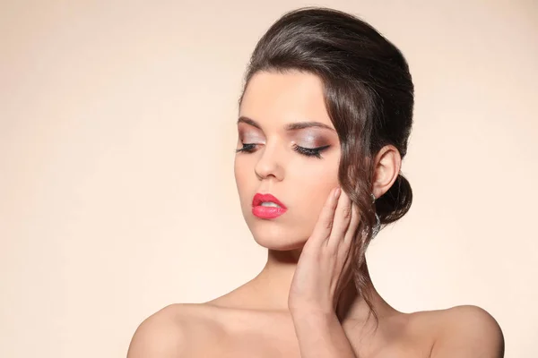Retrato de mujer joven con hermoso maquillaje profesional sobre fondo de color — Foto de Stock