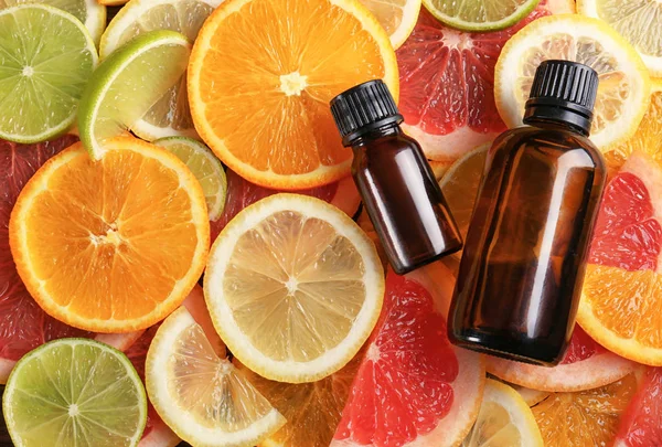 Bottles of essential oil on citrus slices — Stock Photo, Image