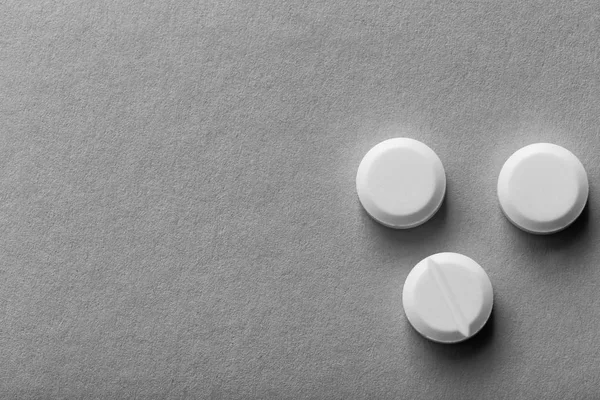 Белые таблетки на сером фоне — стоковое фото