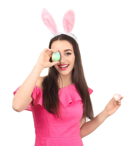 Mooie jonge vrouw met paaseieren en bunny oren op witte achtergrond — Stockfoto