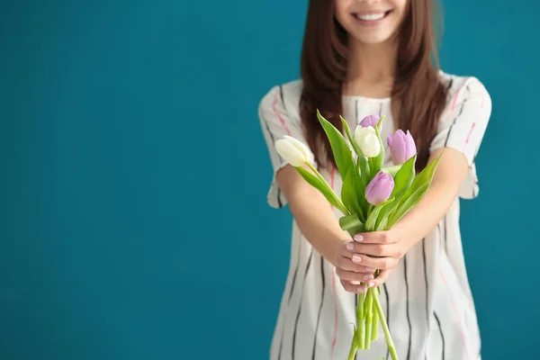 Beautiful young woman with bouquet of tulips on color background, closeup — Stock Photo, Image