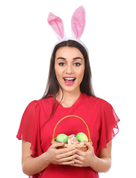 Bella giovane donna con uova di Pasqua e orecchie di coniglio su sfondo bianco — Foto Stock