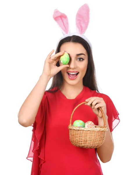 Mooie jonge vrouw met paaseieren en bunny oren op witte achtergrond — Stockfoto