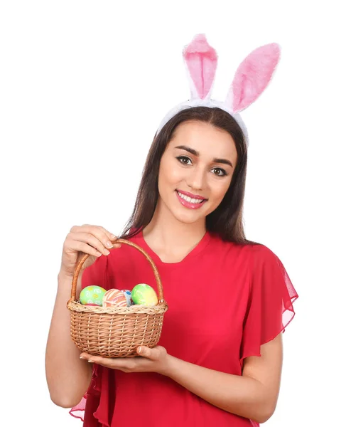 Bella giovane donna con uova di Pasqua e orecchie di coniglio su sfondo bianco — Foto Stock