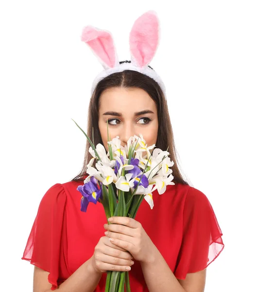 Schöne junge Frau mit Osterhasenohren und Blumenstrauß auf weißem Hintergrund — Stockfoto
