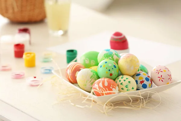 Teller mit bunt bemalten Ostereiern auf dem Tisch — Stockfoto