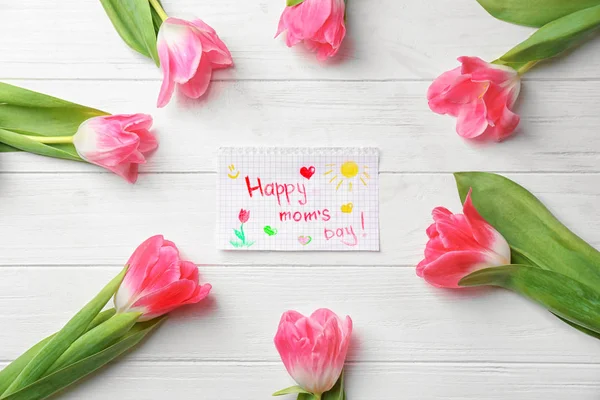 Beautiful tulips and handmade card for Mother\'s Day on white wooden background, top view