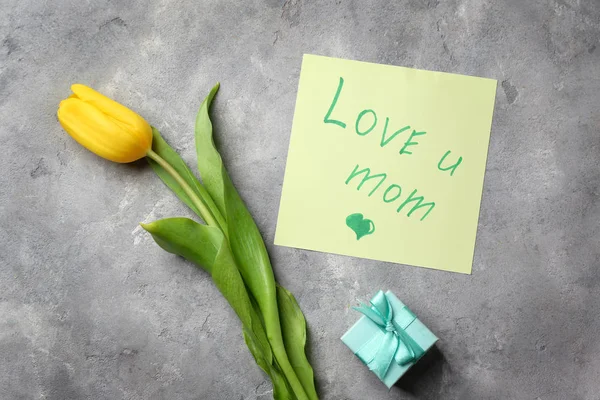 Belle tulipe et carte à la main pour la fête des mères sur fond gris texturé, vue sur le dessus — Photo