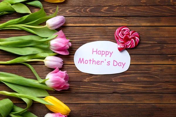 Prachtige tulpen, snoep en handgemaakte kaart voor Mother's Day op houten achtergrond, top uitzicht — Stockfoto