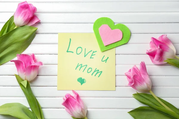 Belles tulipes, coeur en feutre et carte faite à la main pour la fête des mères sur fond blanc en bois, vue de dessus — Photo