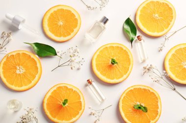 Şişe esans ve portakal dilimleri açık renkli, üstten görünüm