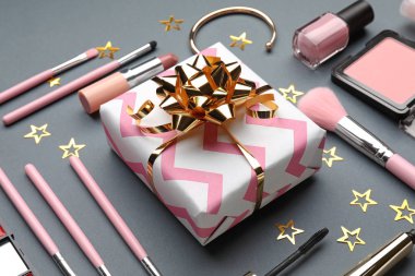 Hediye kutusu ve gri arka plan üzerinde Dekoratif kozmetik kümesi kompozisyonu