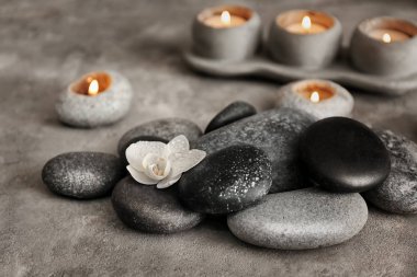 Spa taşlar ve gri masada güzel orkide çiçek