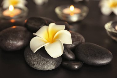 Spa taşlar ve siyah masada güzel çiçek yığını