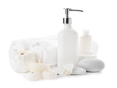 Güzel spa kompozisyon ile kozmetik, Masaj taşlar ve beyaz arka plan üzerinde yanan mumlar