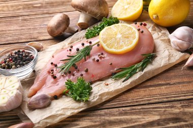 Ahşap masa üzerinde çiğ tavuk fileto ile kompozisyon