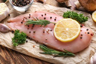 Otlar ve baharatlar ahşap tablo, closeup ile çiğ tavuk fileto