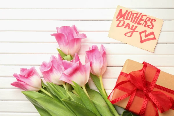 Prachtige tulpen, doos van de gift en handgemaakte kaart voor Mother's Day op witte houten achtergrond — Stockfoto