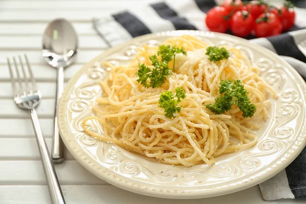 टेबल पर स्पैगेटी और पनीर के साथ प्लेट। स्वादिष्ट पास्ता व्यंजनों — स्टॉक फ़ोटो, इमेज