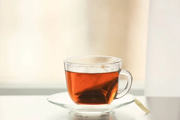 Coupe en verre de thé chaud savoureux sur la table — Photo