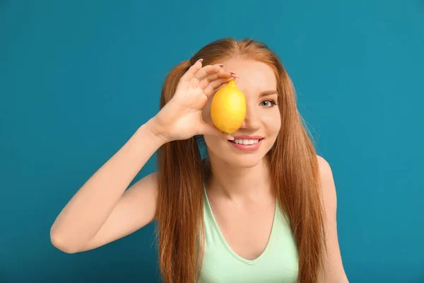 Beautiful young woman with citrus fruit on color background — Stock Photo, Image