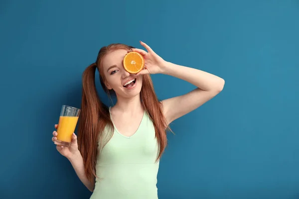 Mulher bonita com frutas cítricas e vidro de suco no fundo de cor — Fotografia de Stock