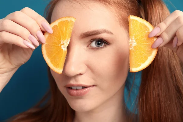 Beautiful young woman with slices of citrus fruit on color background, closeup — Stock Photo, Image