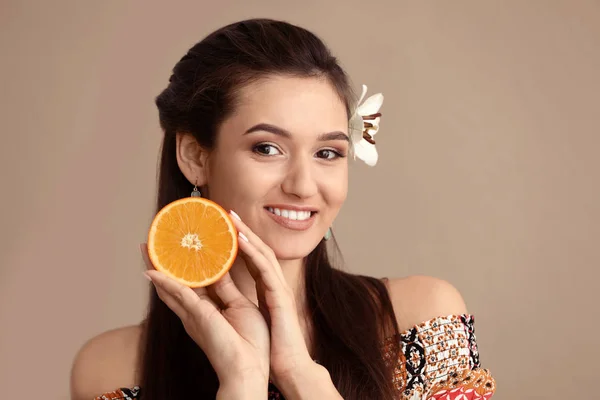 Beautiful young woman with citrus fruit on color background — Stock Photo, Image