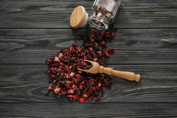 Sterty suchych hibiscus herbata z drewniana miarka na stole — Zdjęcie stockowe