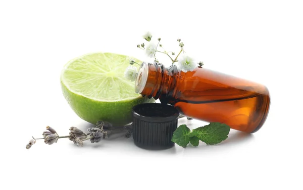 Flaska av citrus eterisk olja, lime och blommor på vit bakgrund — Stockfoto