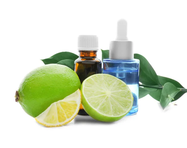 Bottles of citrus essential oil and fruits on white background — Stock Photo, Image