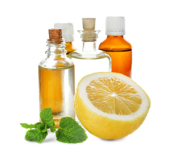 Bottles of citrus essential oil and lemon on white background — Stock Photo, Image