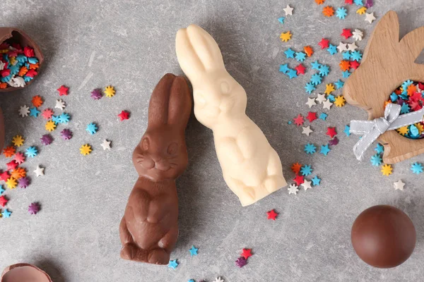 Krásná skladba Velikonoční čokoládové zajíčky, vajíčka a sypání na šedém pozadí — Stock fotografie