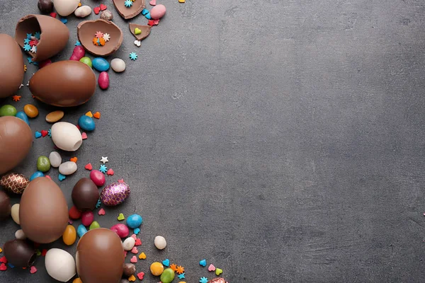 Composición con huevos de Pascua de chocolate y dulces de colores sobre fondo gris — Foto de Stock