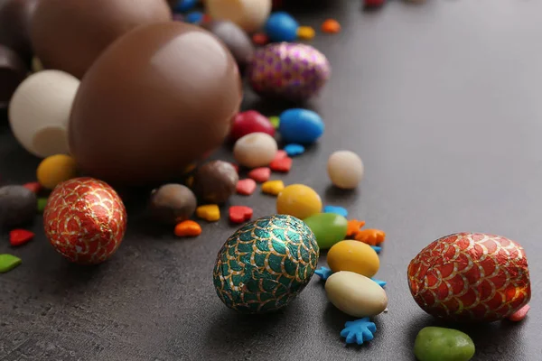 Velikonoční vejíčka čokoládová s barevné sypání a cukroví na stole — Stock fotografie