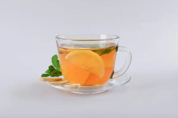 Чашка вкусного чая с мятой, имбирем и лимоном на сером фоне — стоковое фото
