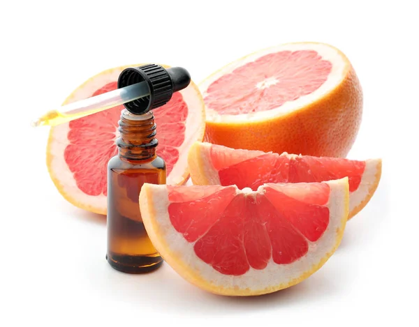 Dropper and bottle of citrus essential oil with sliced fruit on white background — Stock Photo, Image