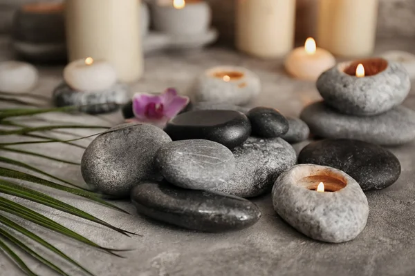 Beautiful spa composition with stones and candles on grey textured background — Stock Photo, Image