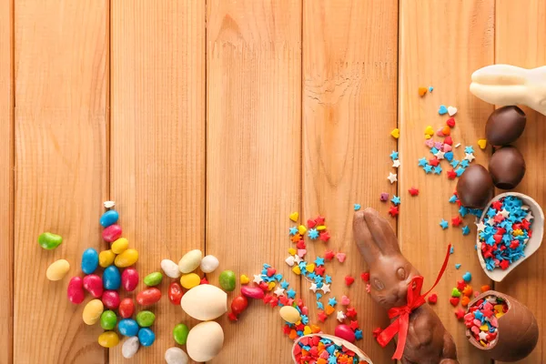 Hermosa composición de Pascua con conejitos de chocolate y caramelos sobre fondo de madera — Foto de Stock