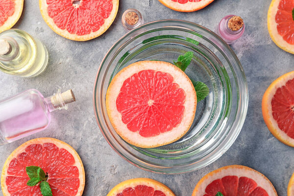 Composition with bottles of citrus essential oils and bowl on table
