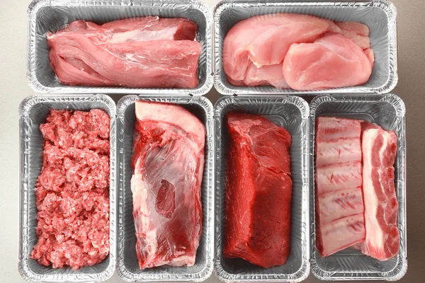 Ωμό κρέας σε αλουμινόχαρτο δοχεία, κοντινό πλάνο — Φωτογραφία Αρχείου