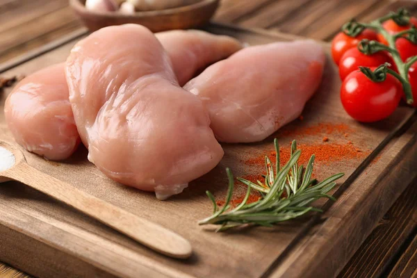 Raw chicken fillet on wooden board. Fresh meat products