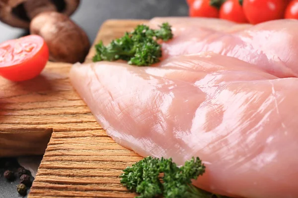 Raw chicken fillet with herbs on wooden board, closeup — Stock Photo, Image