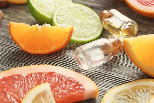 Lahve s esenciální oleje a citrusové plody na dřevěné pozadí — Stock fotografie