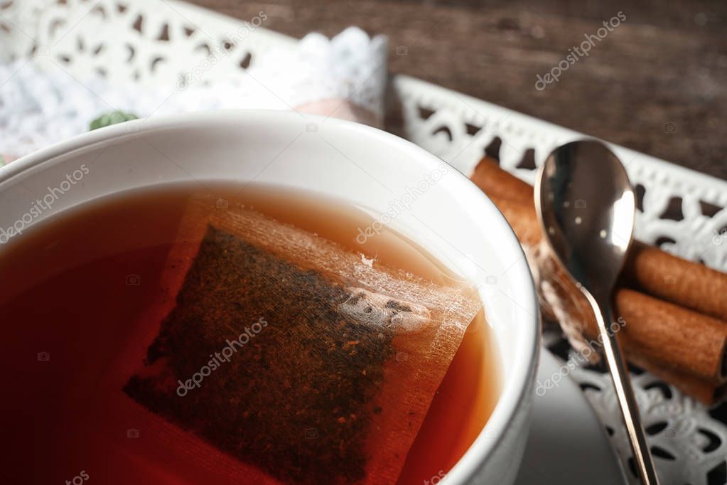 Mug of hot tea with teabag on table, closeup
